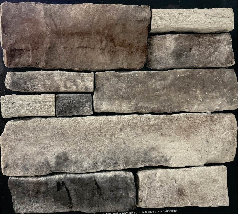 Country Ledge – Norris Gray sample board. Gray-green and taupe pieces with darker accents and a weathered face.