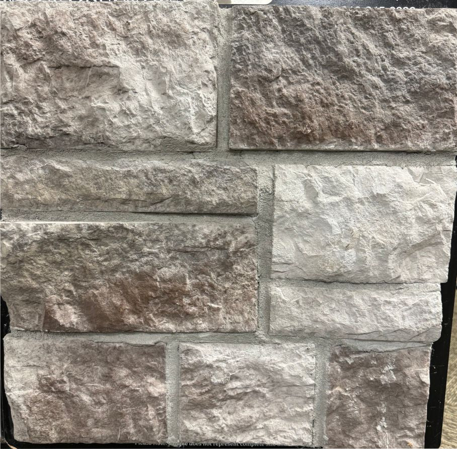 Dimensional – Rushmore sample board. Gray-mauve and light gray blocks with a rough face, shown with a gray mortar joint.