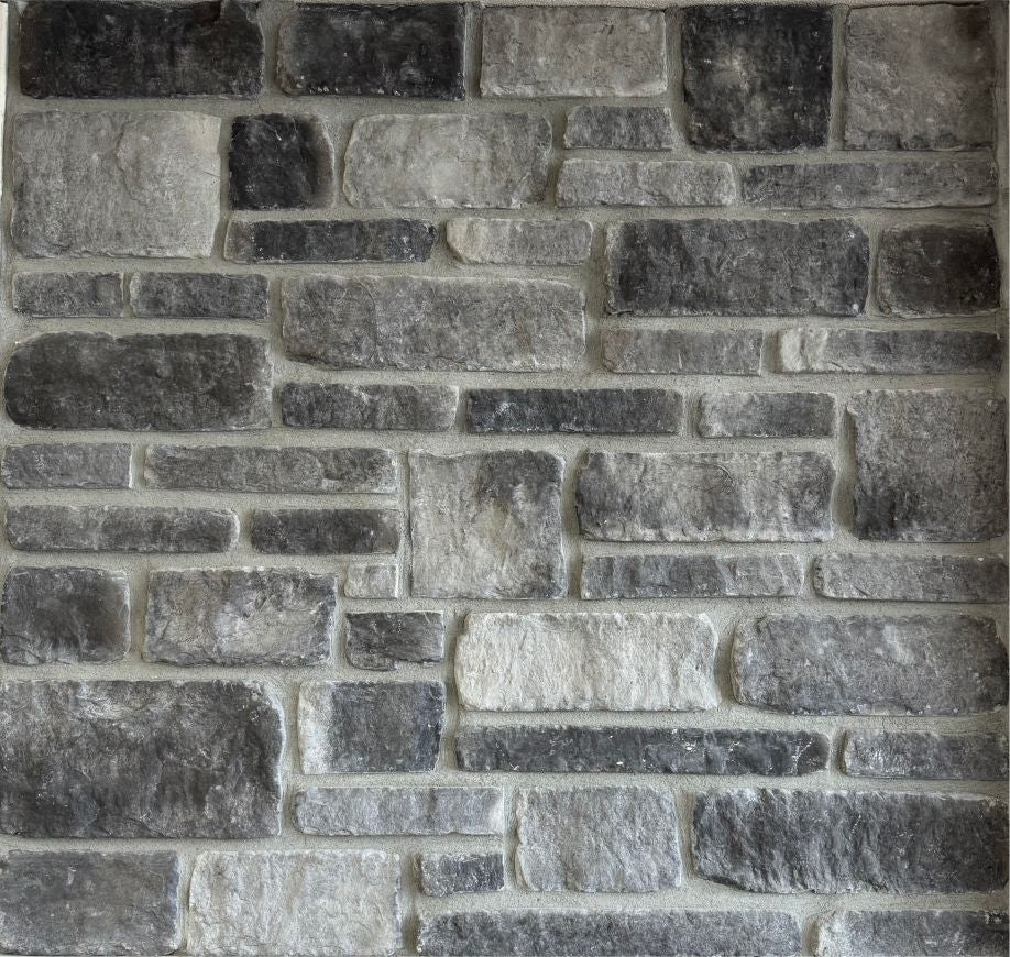 Tumbled – Dark Night sample board. Charcoal and gray pieces with softened edges, shown with a gray mortar joint.