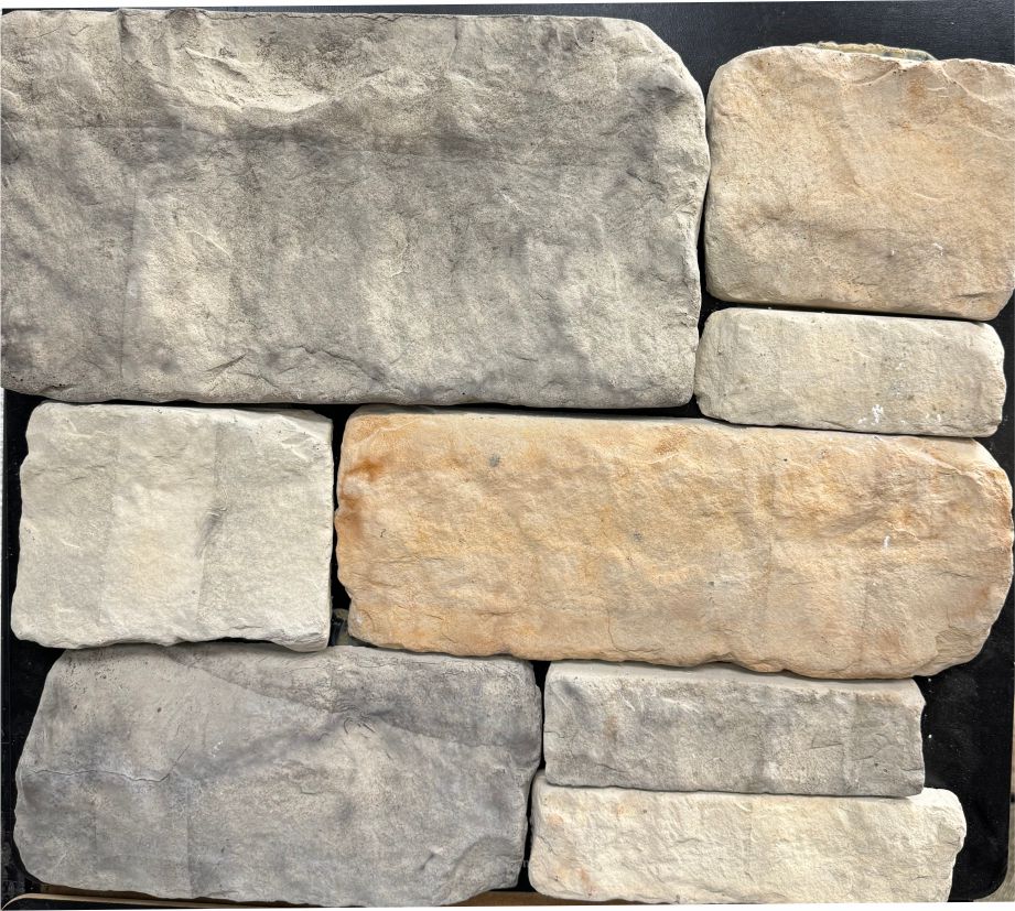 Tumbled – Suede sample board. Gray, cream and buff pieces with softened edges and a warm orange-buff accent.
